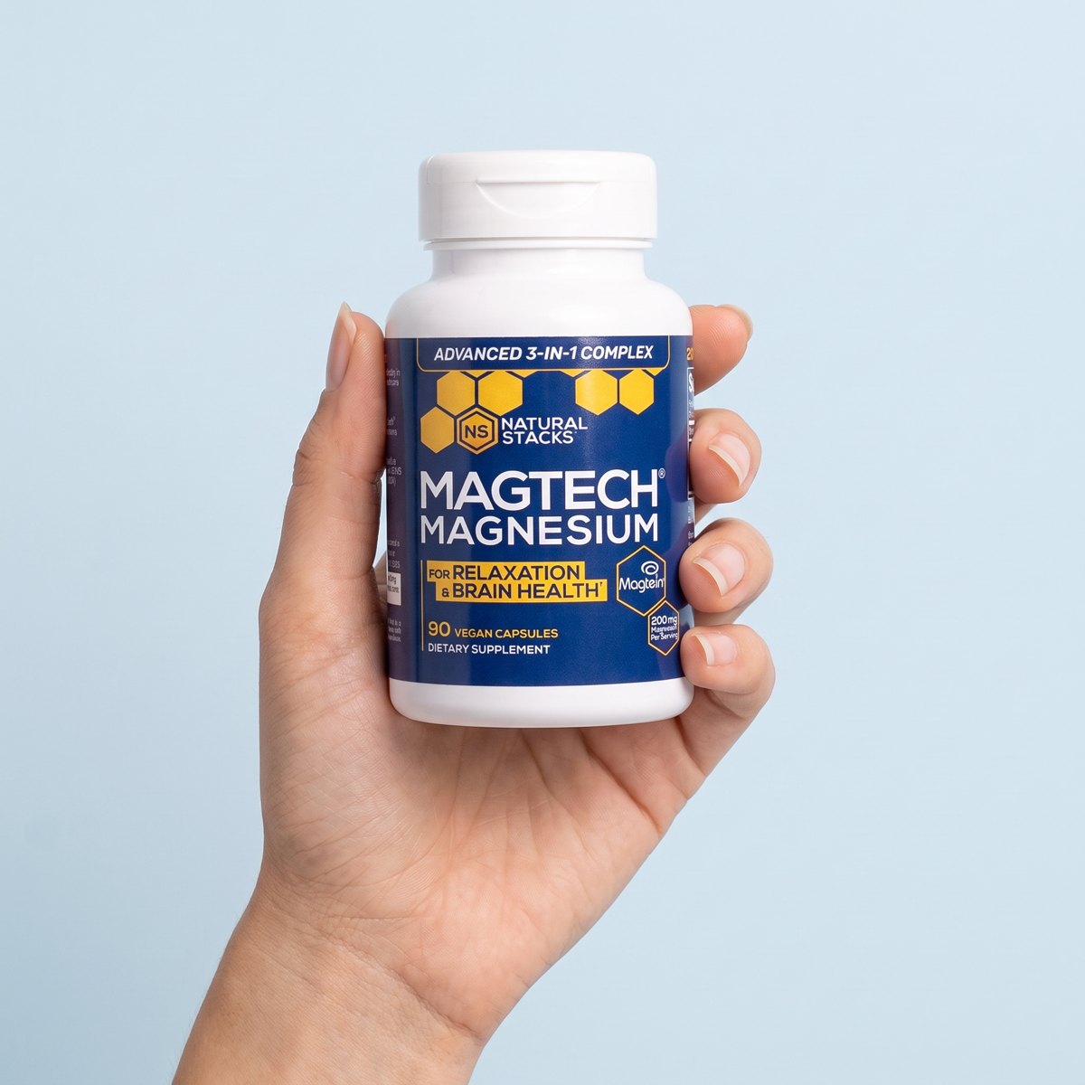 Hand holding a bottle of MagTech® Magnesium