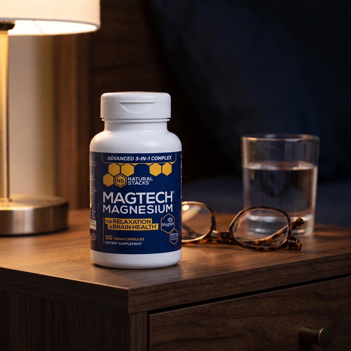 MagTech on a bedside table with reading glasses and a glass of water