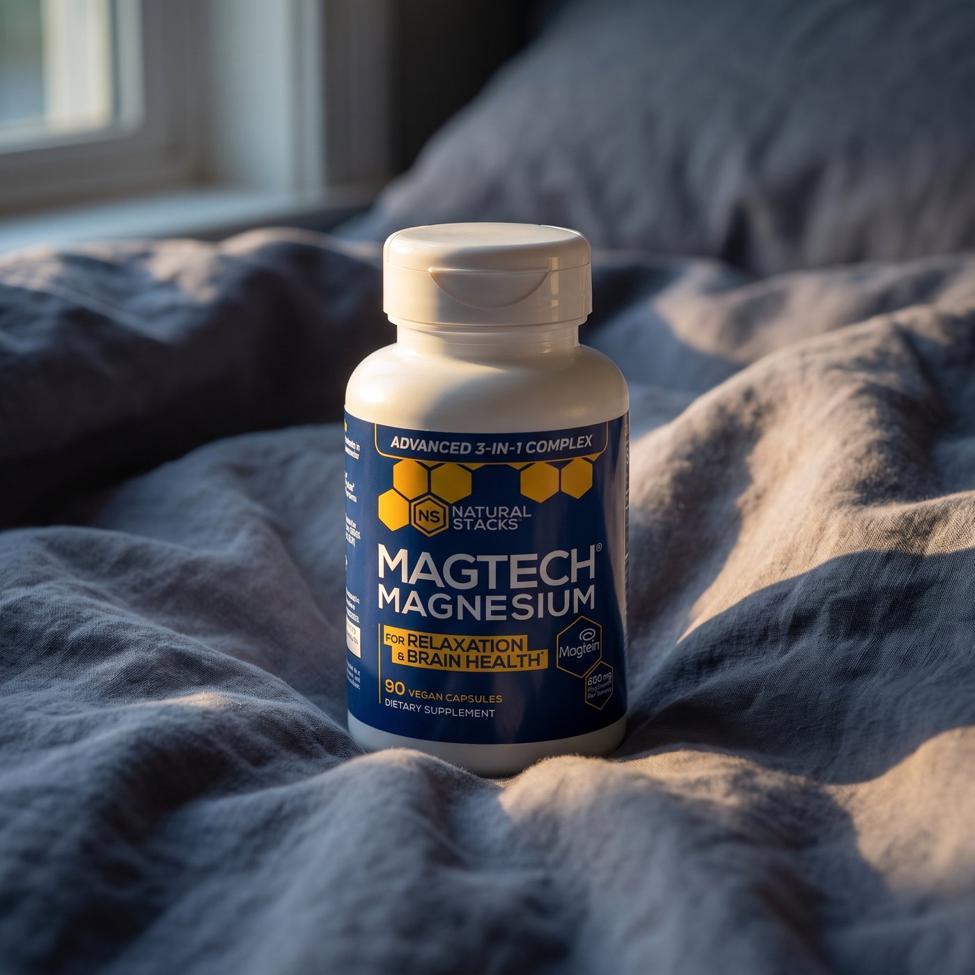 MagTech bottle on grey linen bedding in pre-dawn light